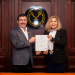 El rector Dámaso Anaya y Norma Laura Barrientos muestran el nombramiento de la nueva dirección de la Prepa UAT Tampico